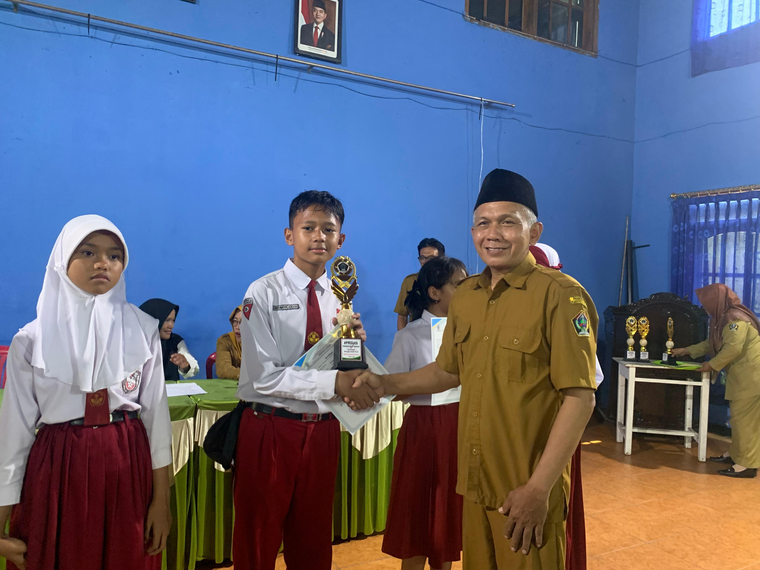 Azka menerima apresiasi dari kepala sekolah untuk lomba cerpen FLS3N